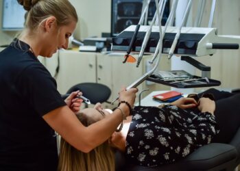 woman in black and white floral top lying on chair
