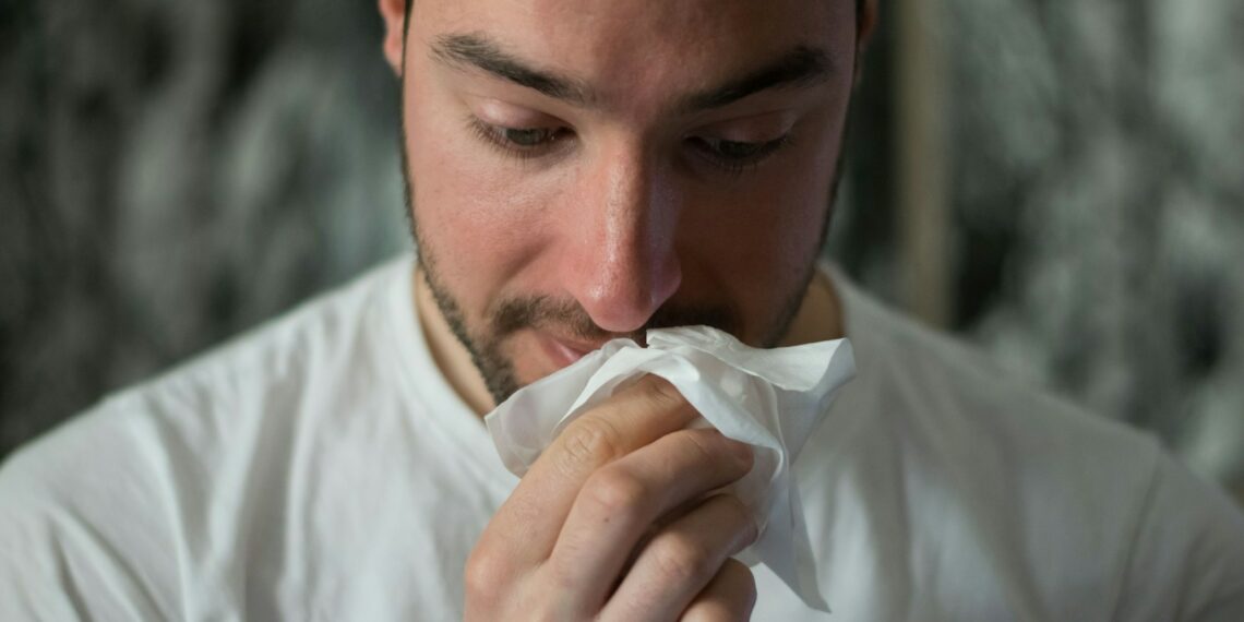 man wiping mouse with tissue paper