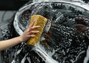 Photo of a Person Cleaning the Window of a Black Car