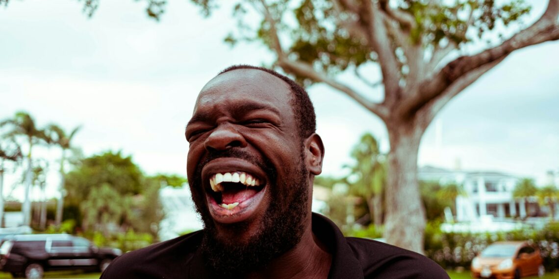 man in black polo shirt smiling