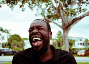 man in black polo shirt smiling