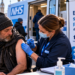 Ilustracja mobilnego punktu NHS oferującego bezpłatne szczepienia przeciw grypie osobom doświadczającym bezdomności